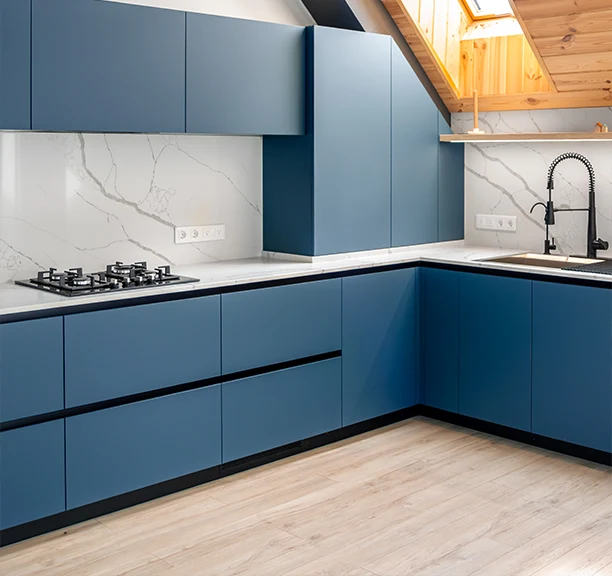 European kitchen with handleless cabinetry and dark stone