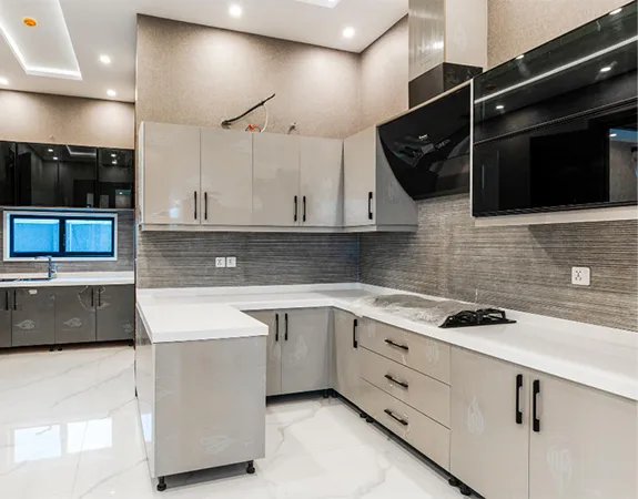 Finished modern kitchen with completed cabinetry, lighting, and stone surfaces